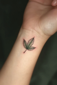 Elegant leaf wrist tattoo for women symbolizing calm renewal and growth — fine-line natural design with soft shading, peaceful 2025 tattoo idea.
