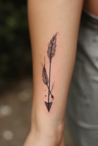 “Arrow with feathers tattoo on forearm – small meaningful tattoo for women symbolizing strength and direction.”