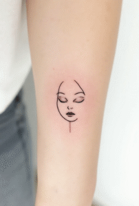 “Simple face outline tattoo – meaningful little tattoo for women symbolizing self-discovery and identity.”