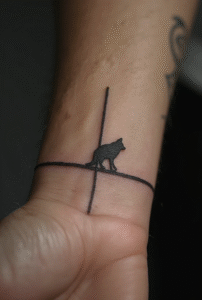 “One-line wolf outline tattoo on a male wrist, drawn with a continuous thin black line for a simple and modern look.”